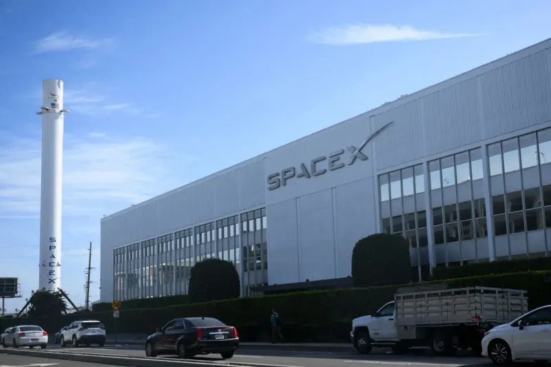 A small portion of a segmented rocket passes through a turnstile, symbolizing SpaceX shares becoming tradable.