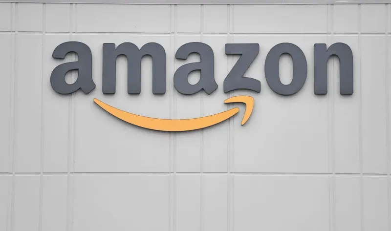 A slingshot aims an upward arrow at a distant cloud of coins, symbolizing Amazon’s ambitious cloud target.