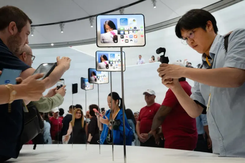 An unbranded smartphone balances between luxury pricing and a coin purse, symbolizing Apple’s pricing challenge.