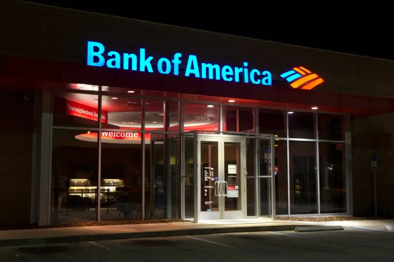 A bank vault sinks beneath two heavy weights, symbolizing the fine and earnings miss pressuring Bank of America.