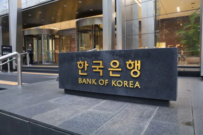 A glowing AI chip lifts South Korea through a tightening ring, symbolizing growth amid higher interest rates.