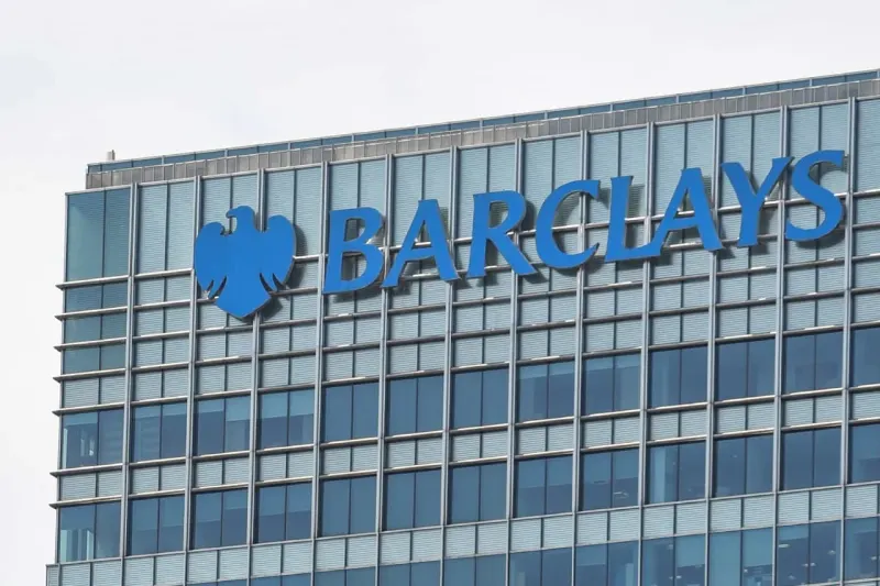 A bank vault fused with a chip pulls five chairs from a ring of 100, symbolizing Barclays’ AI-led job cuts.
