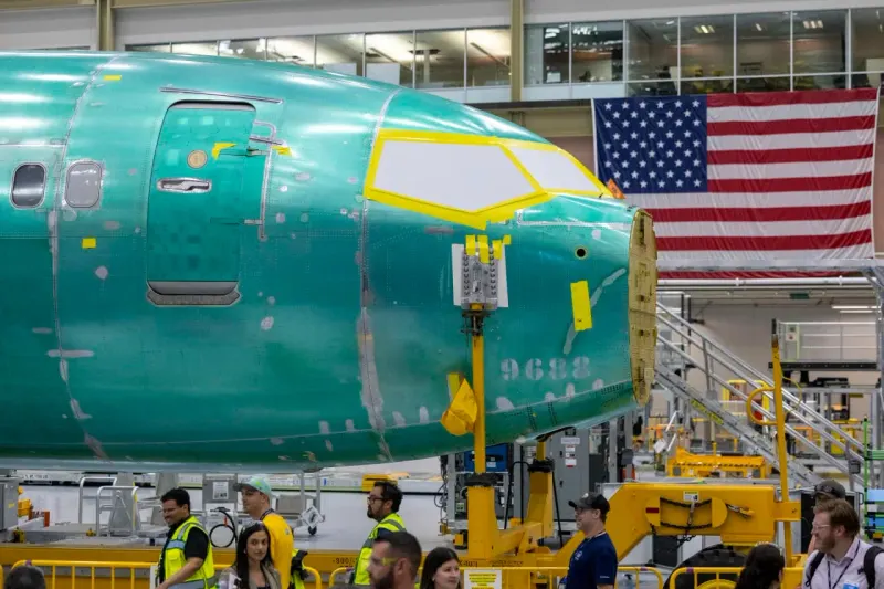 An aircraft built from ascending blocks buckles at a missing piece, symbolizing Boeing’s delivery shortfall.