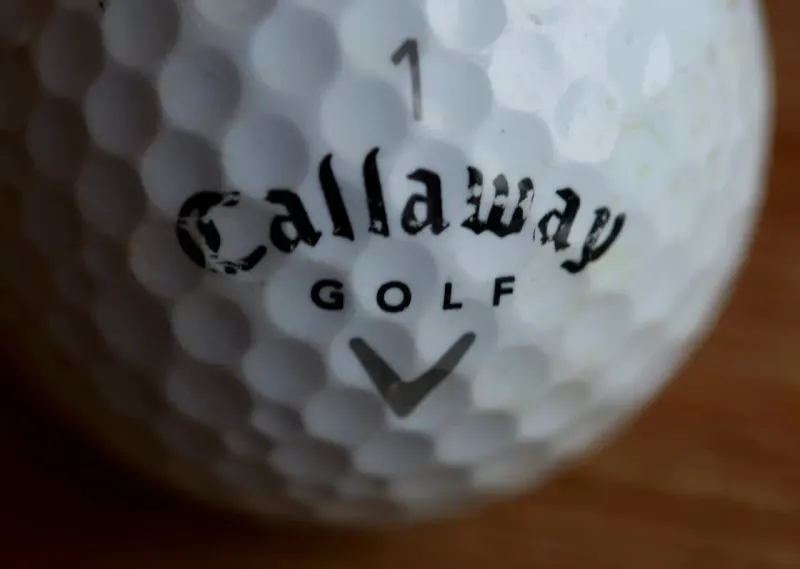 A cracked golf driver topples handshake, retail shelf and television dominoes, symbolizing the widening fallout.