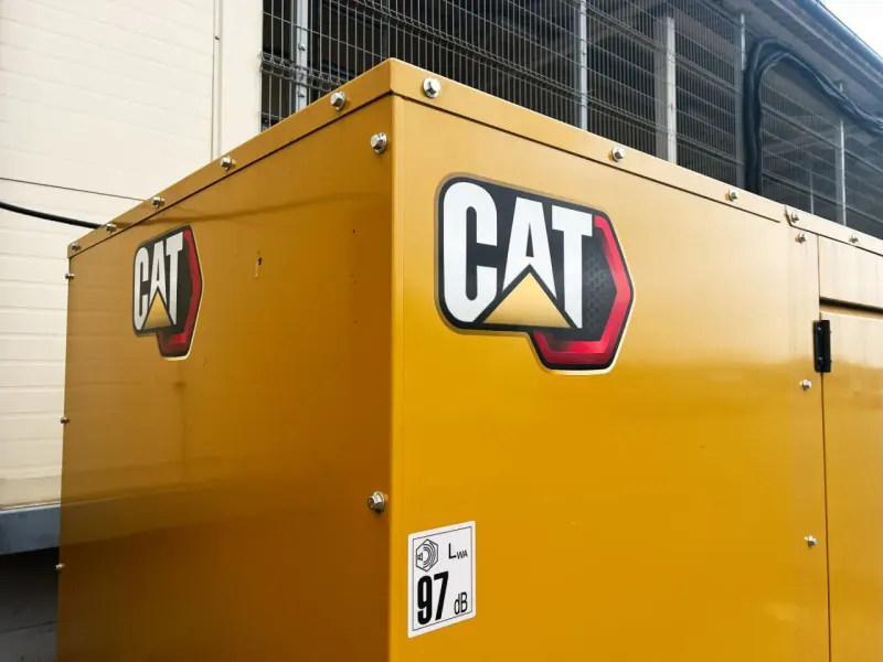 A yellow industrial gear with one glowing circuit segment crumbles and pulls down a market balance.