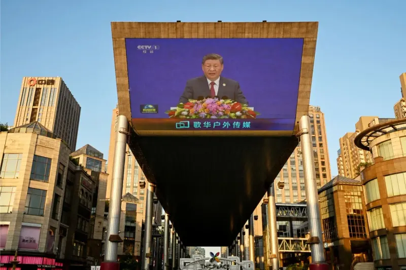 A tilted scale collects tax coins while a cracked debt token falls, symbolizing China’s conflicting payment stance.