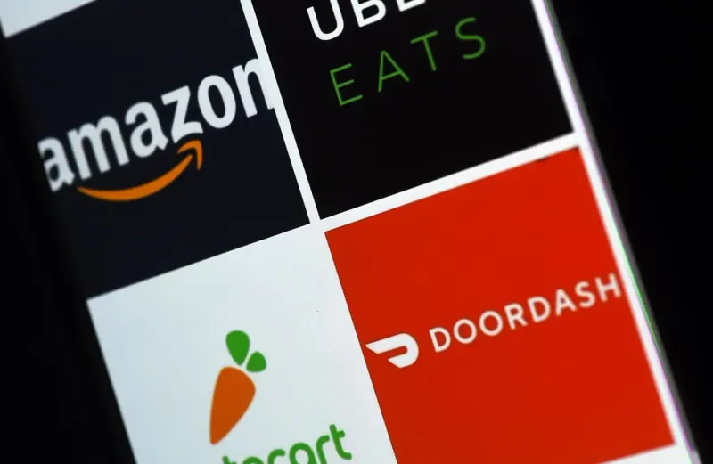 Merged shopping baskets chase two giant wheels, symbolizing DoorDash and Instacart pursuing Walmart and Amazon.