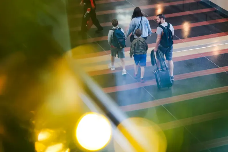 A jet approaches a narrowing calendar opening as rising fare tags threaten to block its path.