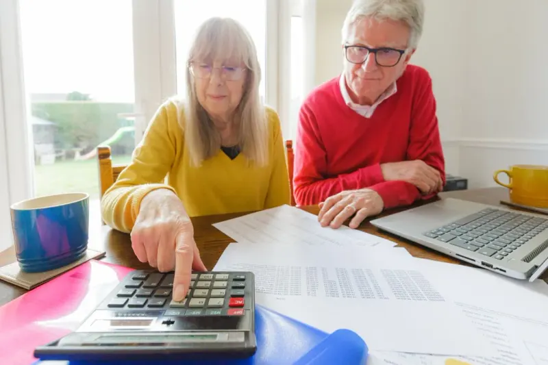A seesaw lifts a retirement nest egg while a weighted credit card sinks, showing the tradeoff from higher rates.