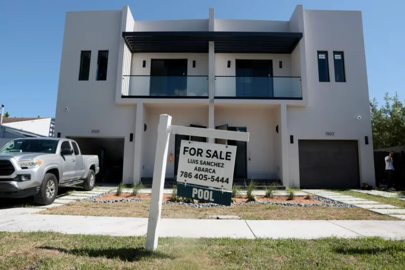 One gold house key among five withstands seven iron weights, symbolizing buyers undeterred by high mortgage rates.