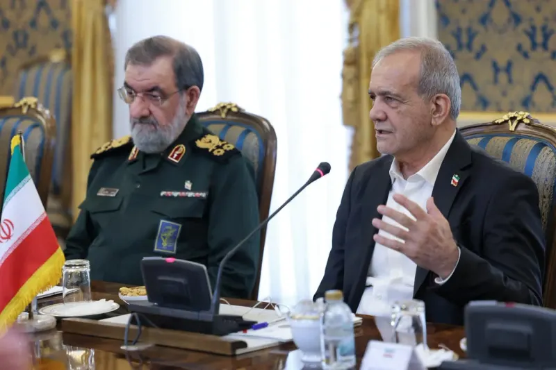 A pendulum barely swings from a sword toward an olive branch, reflecting tentative movement toward an Iran deal.