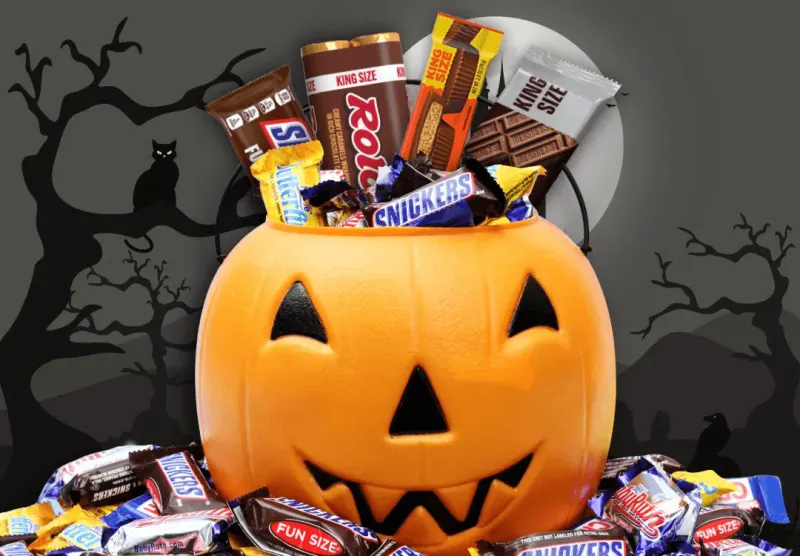 A balance scale compares one large candy bar with small candies and coins, reflecting an unresolved Halloween value question.