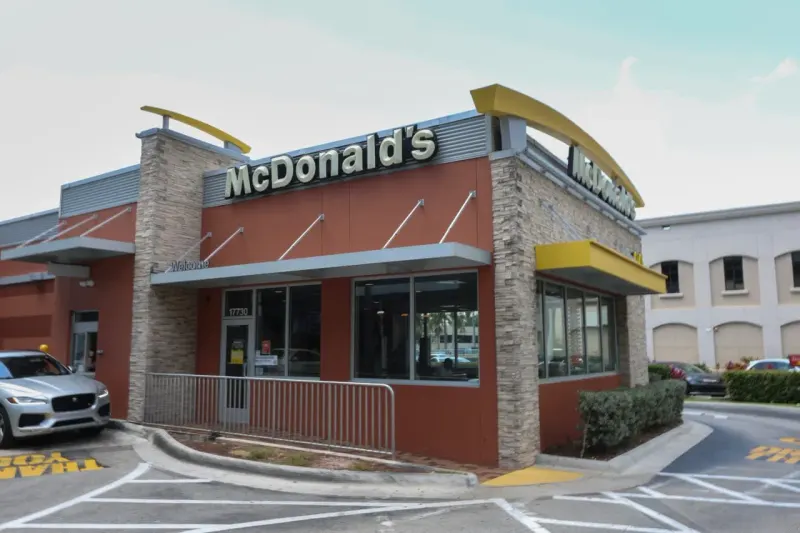 A nugget-shaped circuit key faces a locked turnstile, symbolizing McDonald’s effort to win customers back.