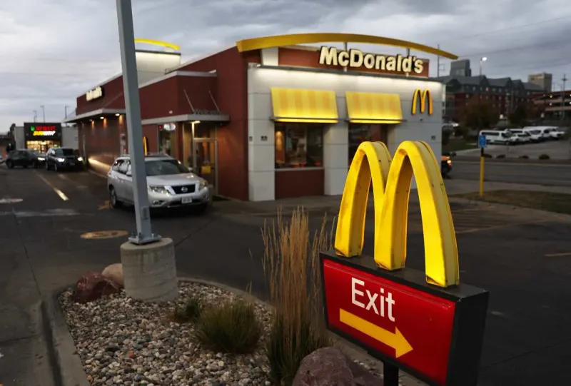 An oversized armored chicken cutlet jams a small takeaway box, symbolizing McDonald’s size and texture complaints.