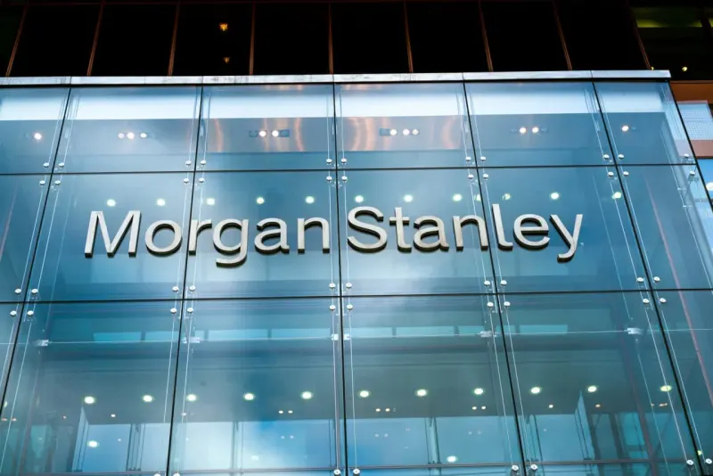 Two compass needles swing upward at a clock’s final tick, symbolizing Morgan Stanley and Goldman Sachs changing Fed calls.
