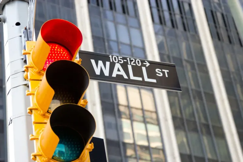 A silicon chip tilts into a red chasm, symbolizing technical warnings of further technology-stock losses.