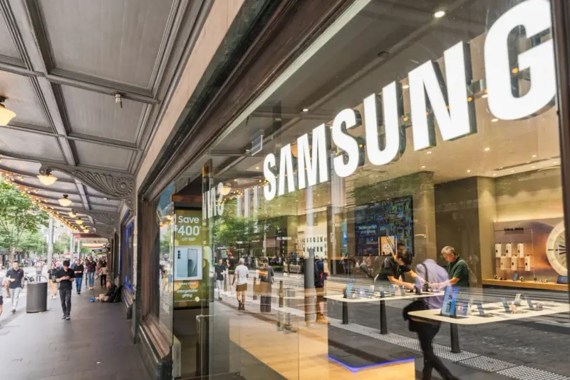 A record-breaking trophy is chained to a sinking market arrow, reflecting Samsung investors’ muted response.