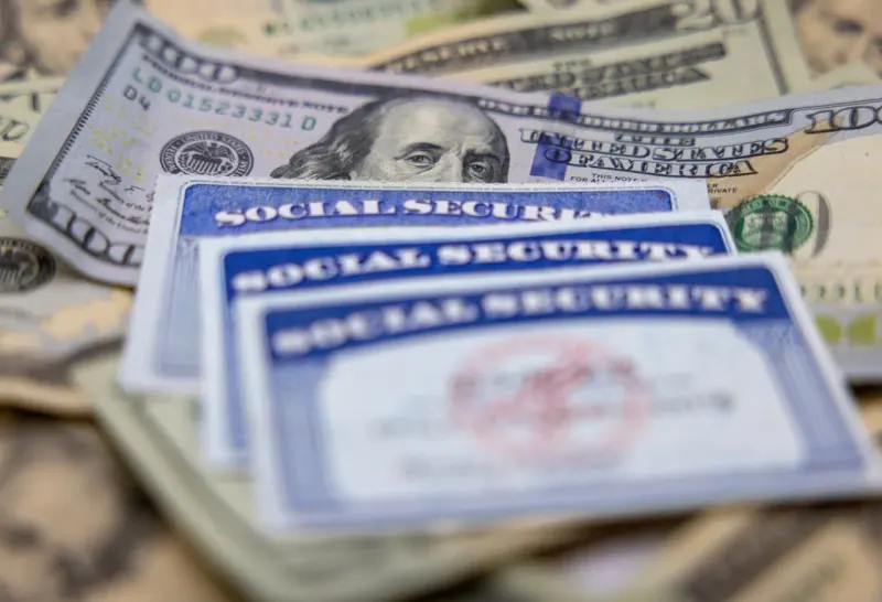 A life preserver supports pension coins above a rising red tide, symbolizing Social Security benefits facing inflation.