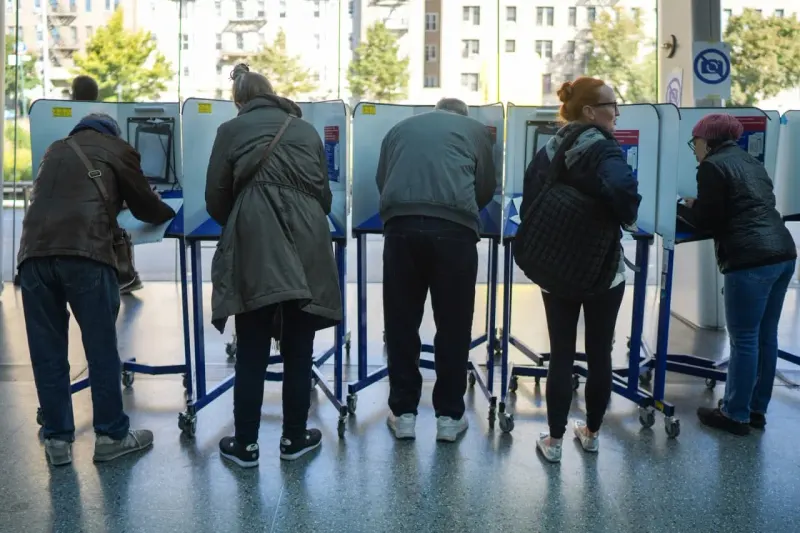 A glass microchip balances against a heavy bond on a seesaw supported by a ballot box.