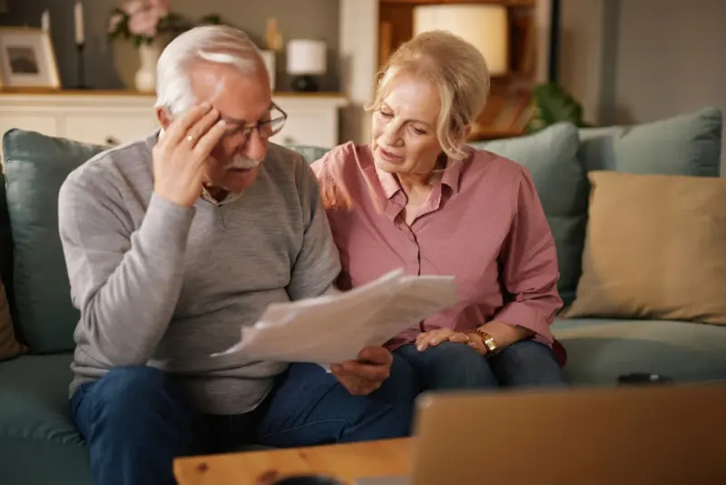 A patchwork umbrella with state-shaped gaps symbolizes uncertainty from state-funded Medicare.