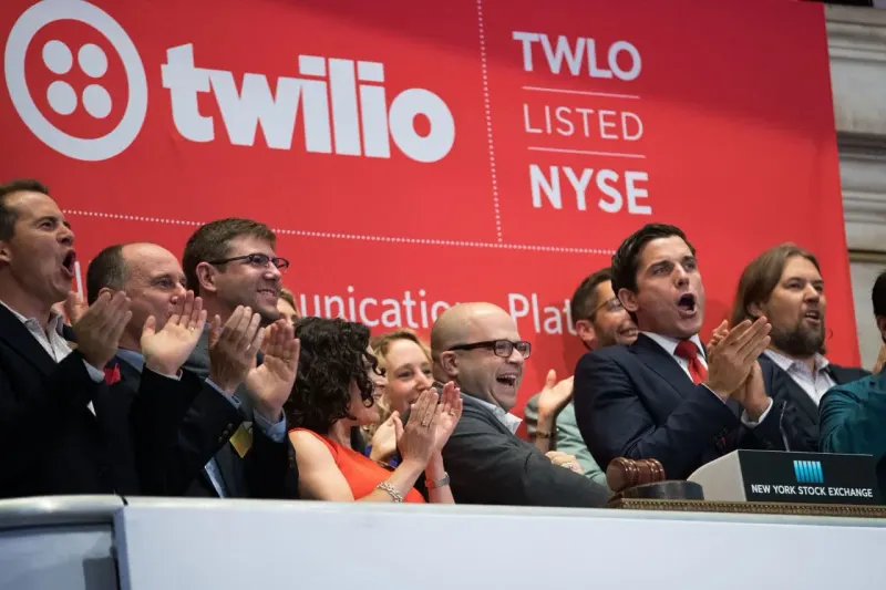 A speech-bubble key enters an index ring as two film reels merge and exit, symbolizing Twilio’s S&P 500 addition.